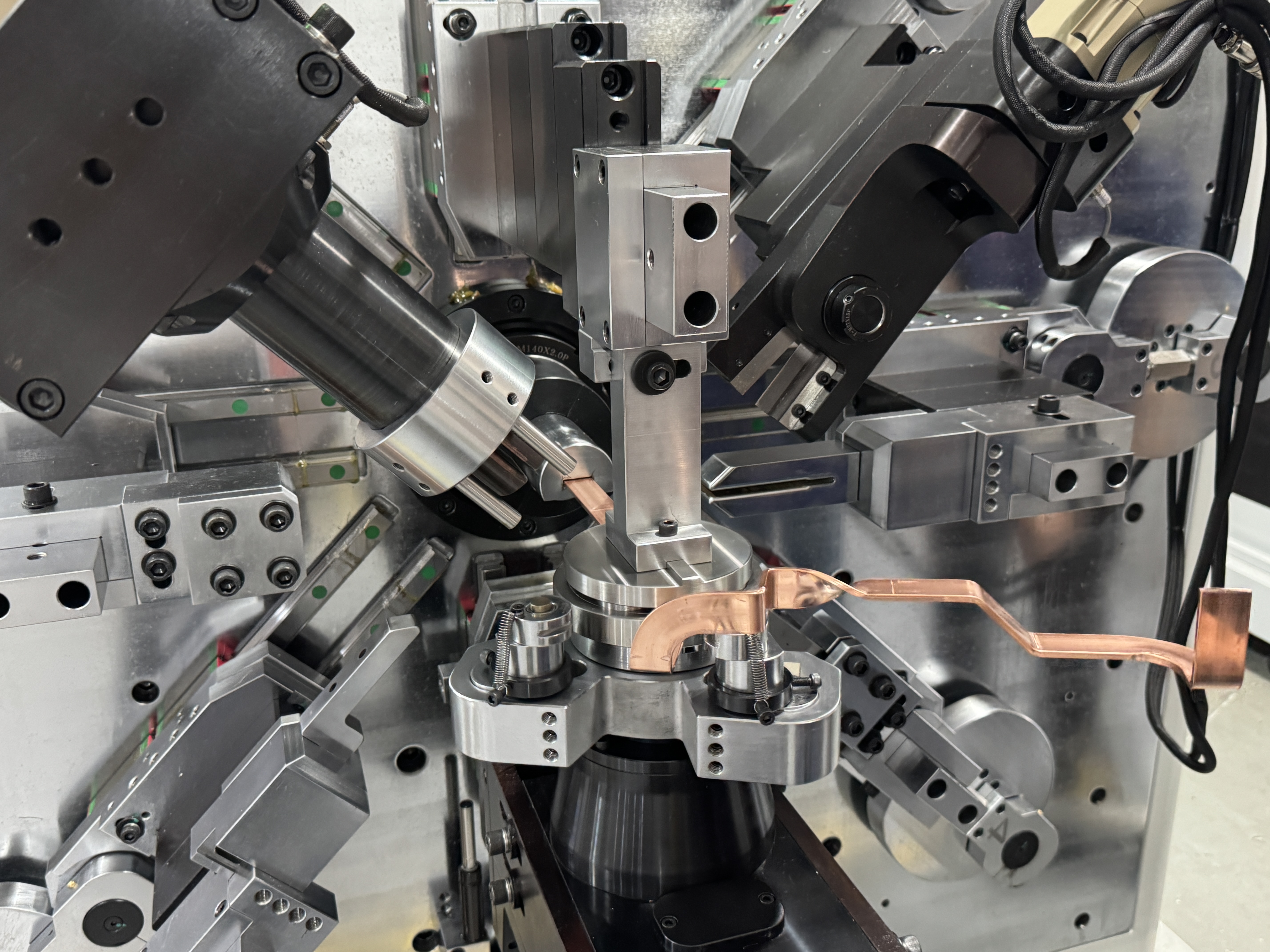 Bending head and tooling of a BELAN busbar bending machine forming a bare copper bar
