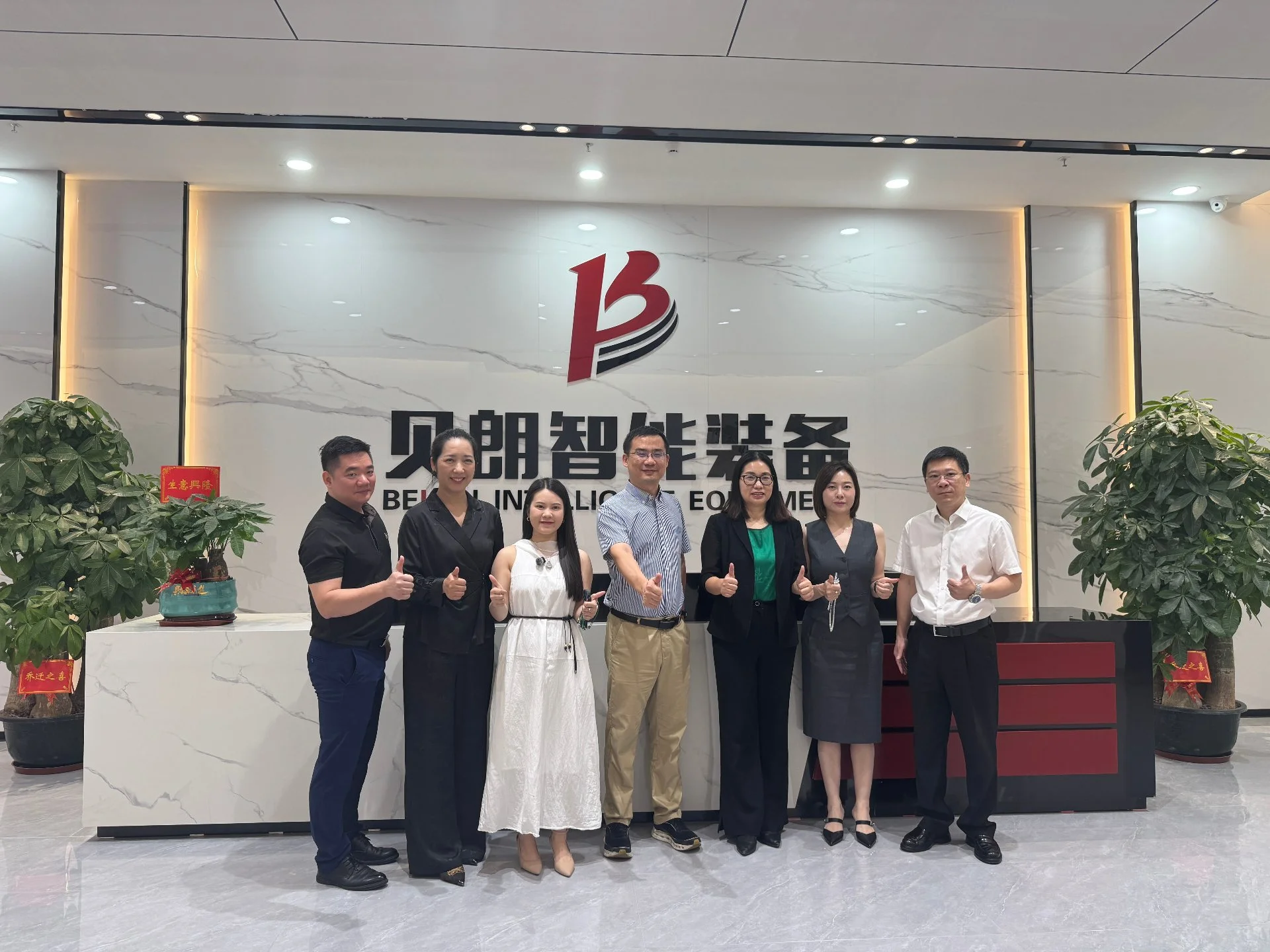BELAN team and the visiting delegation in front of the company lobby wall