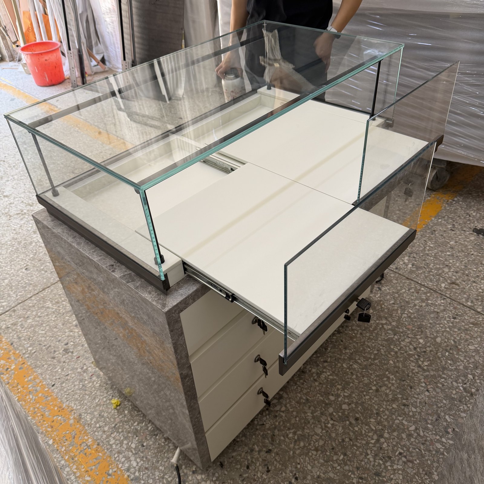 Display counter with sliding glass panels moved aside to open the compartment