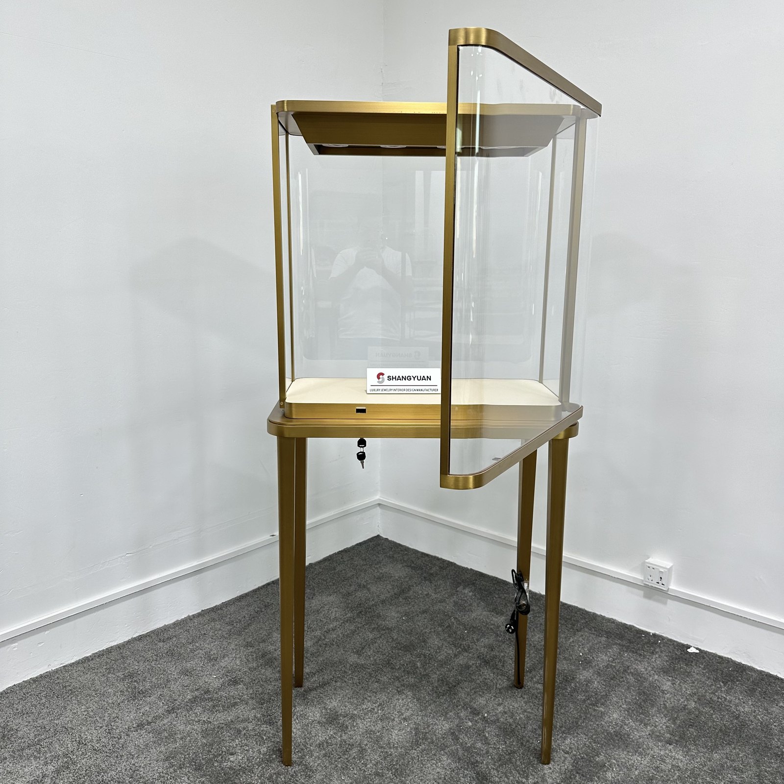 Pedestal jewelry showcase with its front glass door open on side hinges
